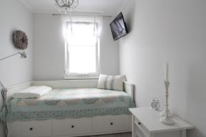 Una habitación blanca con una cama y una ventana en Strandlust, en Ostseebad Nienhagen