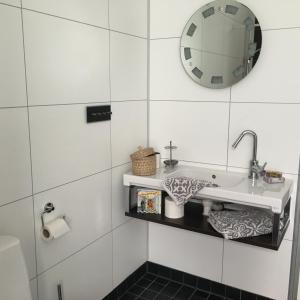 a bathroom with a sink and a mirror on the wall at Maven Kustnära Stugor in Kappelshamn +70 photos