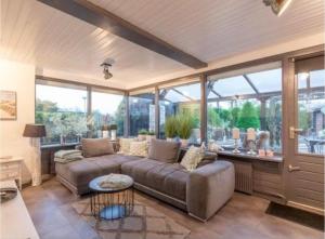 a living room with a couch and some windows at Lichtdurchflutetes Traumhaus 800 Meter zum Strandaufgang, uneinsehbarer Garten mit Terrassenüberdachung, hundefreundlich in Sint Maartenszee