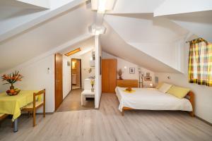 sypialnia na poddaszu z łóżkiem, stołem i biurkiem w obiekcie Apartments Ivo with Sea View w Bašce