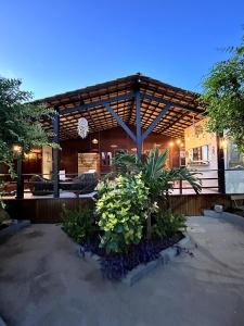 a building with a pavilion with plants in front of it at Pousada Aventurine Noronha in Fernando de Noronha