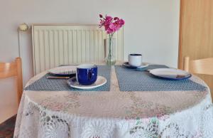 a table with a table cloth with a vase of flowers at Waldblick 2 in Kühlungsborn