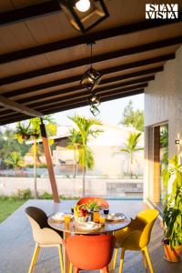 a table and chairs on a patio at StayVista at Asteria Enclave with WiFi, Pool, AC in Nashik