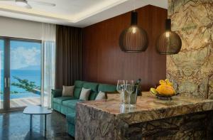 un salon avec un canapé vert et une table dans l'établissement Gardens Hill Resort & Spa, à Beau Vallon