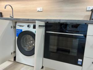 a washer and dryer under a counter in a kitchen at SIA Apartment in Dolní Morava