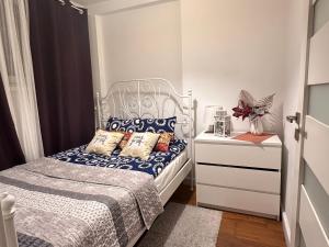 een kleine slaapkamer met een bed en een dressoir bij CENTRUM APARTMENTS MARSZALKOWSKa Parking in Warschau