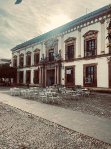 a building with chairs and tables in front of it at Las Fadrique in Córdoba +14 photos