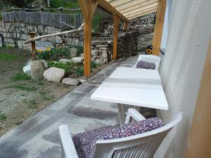 a white table and two chairs with purple cushions at Ferienwohnung Marchnerhof in Terento