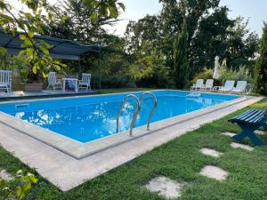 a swimming pool in a yard with chairs around it at Tenuta Nissole in Rocchetta Tanaro