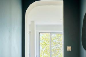 a mirror in a room with a window at Le Nid - Parking - 15 min centre de Lille in Wasquehal
