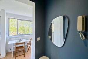 a bathroom with a mirror and a table at Le Nid - Parking - 15 min centre de Lille in Wasquehal +34 photos