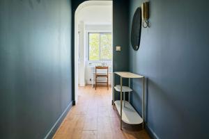 a hallway with a blue wall and a table at Le Nid - Parking - 15 min centre de Lille in Wasquehal