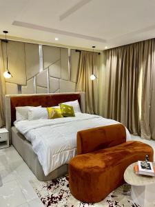 Un dormitorio con una cama grande con cabecero de madera. en Luxury Penthouse with Private Rooftop Lounge & City View - Lekki Home Fairy, en Lekki