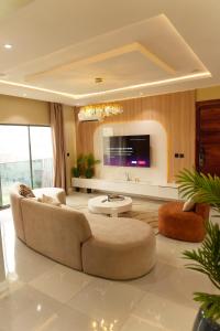 Una sala de estar con un sofá y un televisor. en Luxury Penthouse with Private Rooftop Lounge & City View - Lekki Home Fairy, en Lekki