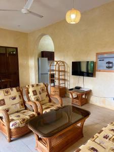 Il comprend un salon meublé doté d'une télévision à écran plat. dans l'établissement Flametree Beach Homes, à Diani Beach 49 autres photos