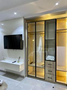 Un baño con TV y un armario de cristal. en Luxury Penthouse with Private Rooftop Lounge & City View - Lekki Home Fairy, en Lekki