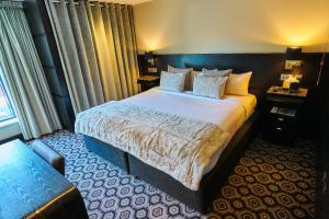 a hotel room with a bed and a couch at The Vincent Hotel in Southport