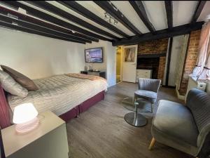a bedroom with a bed and a couch and a chair at PAVILION ORPINGTON Hotel & Lounge Bar in Foots Cray