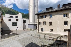 a building with a clock tower next to a building at Palazzo Mysanus Samedan in Samedan
