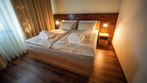 a bedroom with a large bed with white sheets and pillows at Hiša na Hribu- A Peaceful Hilltop Escape above river Kolpa in Kostel