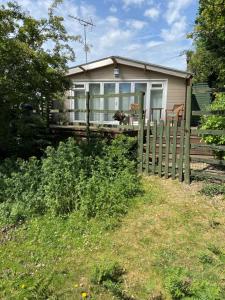 a house with a fence in front of it at New Forest 2 bedroom Guest Suite & Hot Tub in Ibsley +18 photos