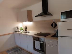 a kitchen with white cabinets and a white refrigerator at Ferienwohnung Marchnerhof in Terento