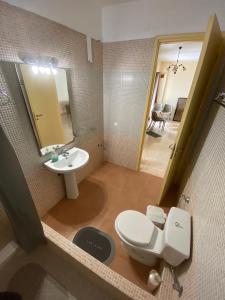 a bathroom with a toilet and a sink and a mirror at Βίλα Ηρώ in Riglia +36 photos