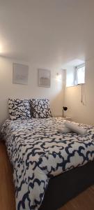 a bedroom with a bed with a black and white comforter at L'Atelier Gauthier in Cholet