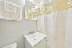 a white bathroom with a sink and a toilet at Flint Motel by OYO MI Near I-475 in Flint +40 photos