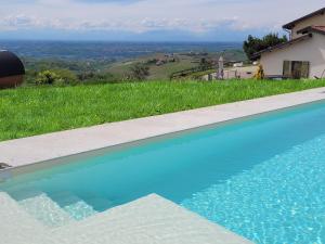a swimming pool with a view of a house at Assiolo Relais in Dogliani
