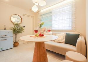 a living room with a table and two glasses of wine at Hongdae#Hongik Univ Station 9 min Walk#Airport Railroad Access#Free Parking#Free Netflix#Free WiFi#Luggage Storage#Washer and Dryer in Seoul