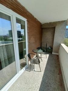 a patio with chairs and a table on a balcony at Urban View - Main Square Gate Apartment in Skopje