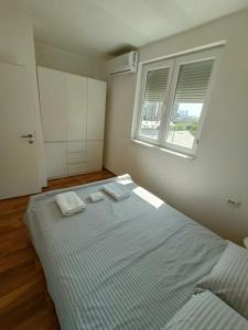 a bedroom with a bed with two towels on it at Urban View - Main Square Gate Apartment in Skopje