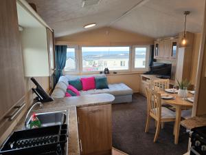 a kitchen and living room with a couch and a table at Eyemouth Caravan in Eyemouth