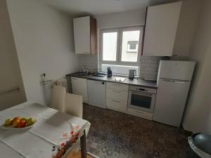 a kitchen with a table with a bowl of fruit on it at Urban View - Main Square Gate Apartment in Skopje +1 photo