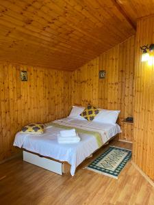 a bedroom with a bed in a wooden room at Salcia Pletoasa in Mahmudia