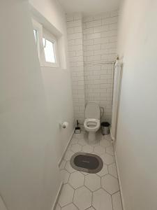 a bathroom with a toilet and a window at Urban View - Main Square Gate Apartment in Skopje