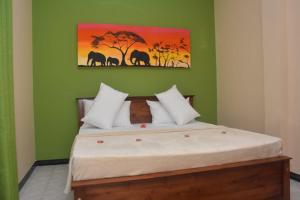 a bedroom with a bed with a painting on the wall at Ocean Gate Residence in Bentota