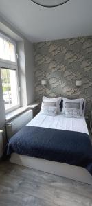 a bedroom with a large bed and a wall at AP Apartment's Zielony in Szczawno-Zdrój