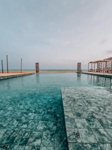 a swimming pool with the ocean in the background at MIADJOE Beach RESORT in Aného