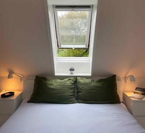 Un dormitorio con una cama y una ventana encima. en Historic Summer House From 1877 With Scenic View, en Stokkemarke