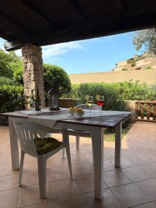 a table and a chair on a patio with wine glasses at Wild Paradise in Costa Paradiso