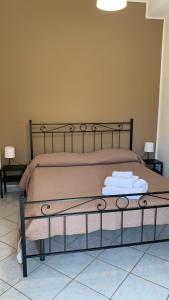 a bedroom with a bed with two towels on it at Home Nala in Giardini Naxos
