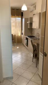 a kitchen with a sink and a table and chairs at Home Nala in Giardini Naxos