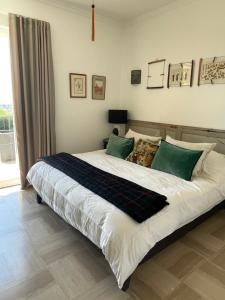 a bedroom with a large bed with green pillows at Villa Helena in Le Cannet
