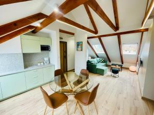 a kitchen and living room with a glass table and chairs at Piastowy Dwór in Jastrzębia Góra