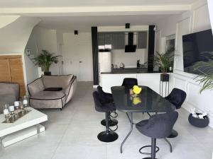 a living room with a black table and chairs at Apartament 5 in Kobylniki