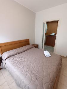 una camera da letto con un grande letto con una coperta bianca di A Casa di Giovy a Taranto