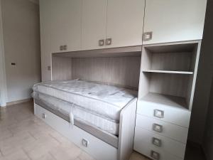 una camera da letto con un letto e armadi bianchi di A Casa di Giovy a Taranto