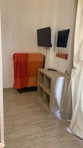 a room with a tv and a table with a television at Home Apollo in Giardini Naxos